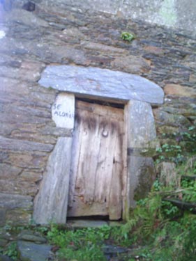 Detalle de la casa de piedra, en la que se muestra una puerta.  - Se abre en una nueva ventana
